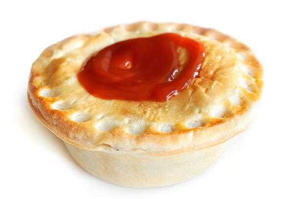 Aussie Meat Pie A traditional Australian Meat Pie with tomato sauce on top. meat pie stock pictures, royalty-free photos & images