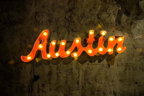 Austin Light Up Metal Sign Hanging on Textured Wall stock photo