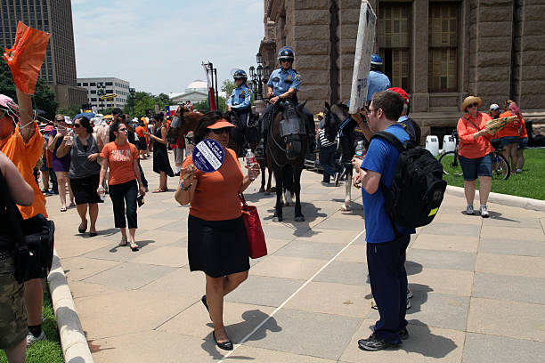 Austin, Texas Abortion Debate, July, 2013 Austin, TX, USA - July 1, 2013:  Mounted police keep an eye on pro-choice and pro-life demonstrators in close proximity outside the Capitol.  Demonstrations were triggered by State Senator Wendy Davis' 11 hour filibuster to block Senate Bill 5, a measure intended to further restrict abortions. texas abortion stock pictures, royalty-free photos & images