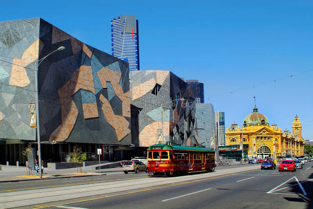 Australia, Victoria, Melbourne, Melbourne, VIC, Australia - November 09, 2006: Flinders Street Station and Federation Square with Australian Centre of Moving Image, public City Circle Tram and cars federation square stock pictures, royalty-free photos & images