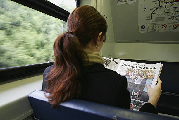 Australian Reaction After London Blasts SYDNEY, NSW - JULY 08: A commuter reads the news on a State Rail Train regarding yesterdays terrorist attack in London July 8, 2005 in Sydney Australia. At least 38 people died in multiple bomb attacks on the London underground and bus network. (Photo by Cameron Spencer/Getty Images) people in train reading newspaper stock pictures, royalty-free photos & images