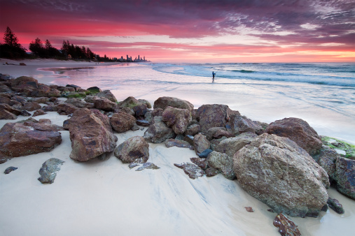 australian seascape at dawn with rocks in foreground (miami beach, queensland, australia)