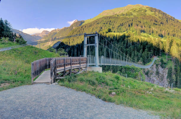 Austria's longest pedestrian suspension bridge in Holzgau Bridge of Holzgau The village of Holzgau is famous for Austria"u2019s longest (200m) pedestrian suspension bridge that opened in 2012, over Höhenbach Canyon, connecting Gföllberg and Schiggenberg. lechtal alps stock pictures, royalty-free photos & images