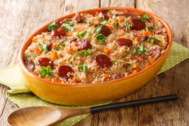 Authentic Arroz de pato duck rice is a traditional recipe from Portugal cooked with red wine, onion, carrot and chorizo close up in the baking dish. Horizontal stock photo