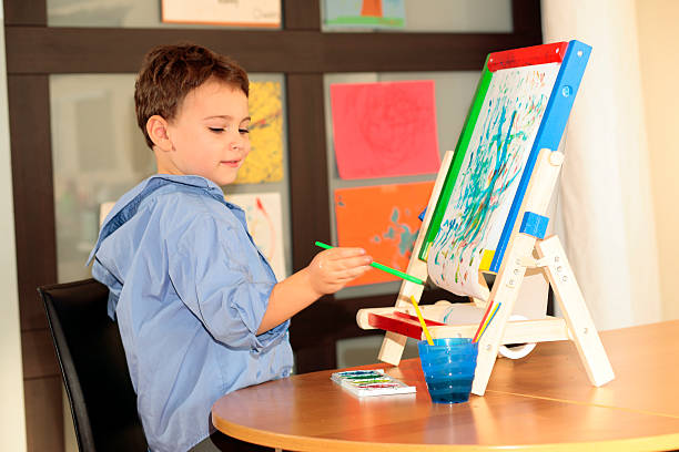 Autistic child painting with easel stock photo