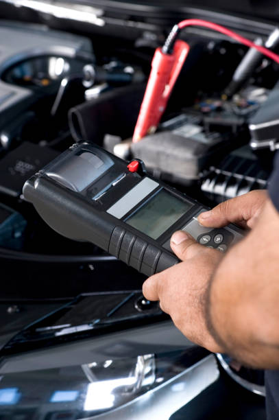 Auto mechanic checking car battery stock photo
