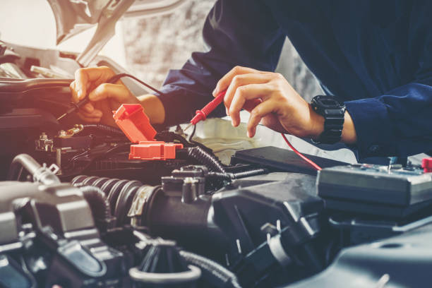 Auto mechanic checking car battery voltage Auto mechanic checking car battery voltage cycle vehicle stock pictures, royalty-free photos & images