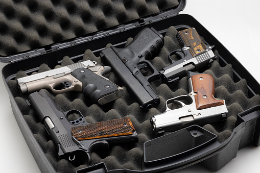 Automatic handguns collection in a plastic hard case on white background