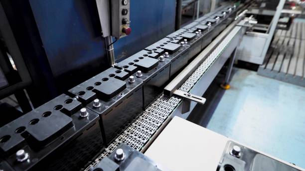 Automatic line for the assembly of car batteries. The black batteries move and collect on the conveyor belt Automatic line for the assembly of car batteries. The black batteries move and collect on the conveyor belt. Production batteries stock pictures, royalty-free photos & images
