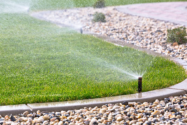 Automatic sprinklers Automatic sprinklers watering grass irrigation equipment stock pictures, royalty-free photos & images