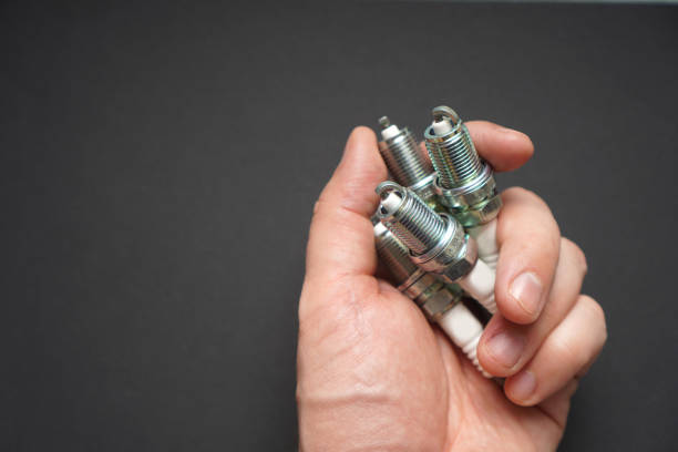 Automobile spark plugs in a man's hand. Background with copy space. Automobile spark plugs in a man's hand. Background with copy space. iridium stock pictures, royalty-free photos & images