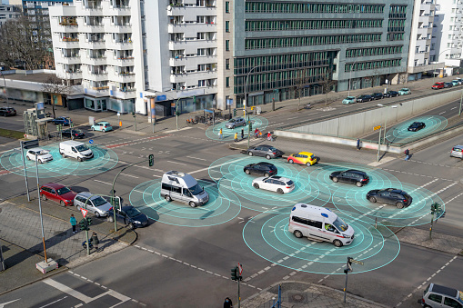 Self driving autonomous cars on multi lane city street. The cars are using radar sensors, wireless communication, GPS and artificial intelligence to navigate and communicate with each other.