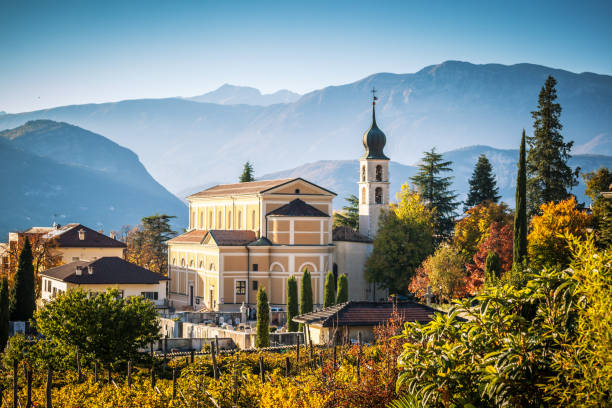 Autumn in Alps with church in Trento stock photo