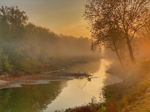 Autumn Sunrise Over the Arkansas River An autumn sunrise in Little Rock, Arkansas  floods the Arkansas River with golden sunlight. michael dean shelton stock pictures, royalty-free photos & images