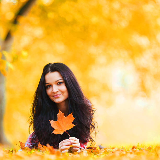 woman on leafs in autumn park