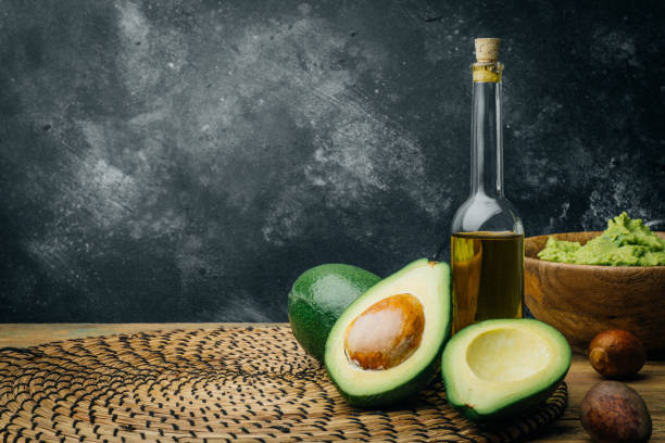Avocado and avocado oil on a wooden background. Copy space. stock photo