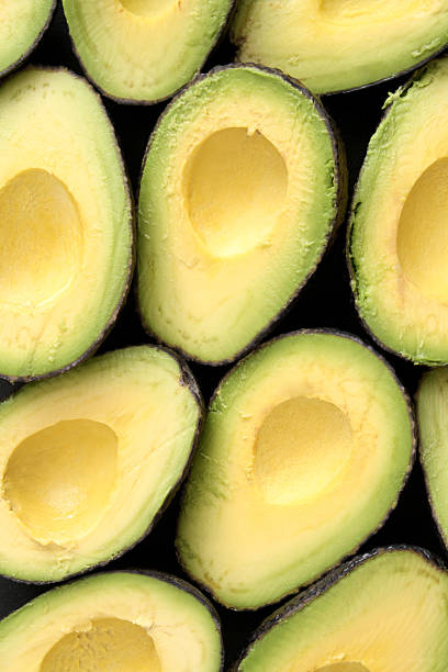 avocado halves - avocado stockfoto's en -beelden