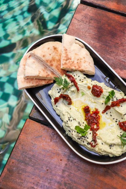 Avocado Hummus with Oilve oil and sundried tomatoes stock photo