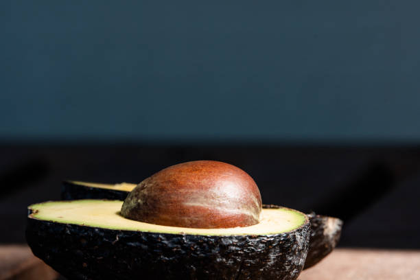 Avocado sliced in half Cut open avocado with bright pit michelle tresemer stock pictures, royalty-free photos & images