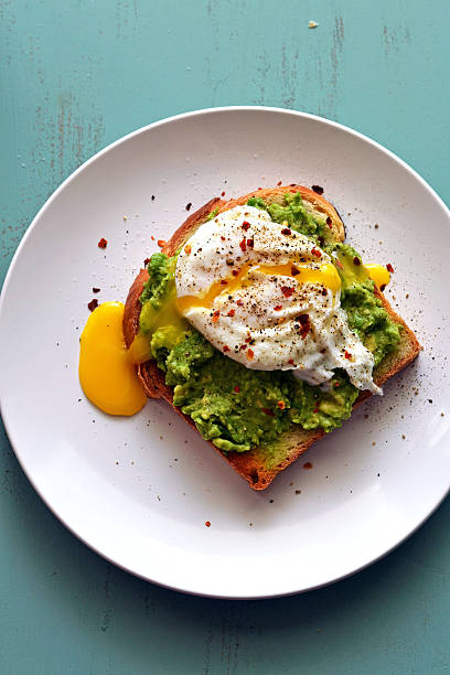 Avocado Toast Easy Avocado Toast with a runny poached egg. poached food photos stock pictures, royalty-free photos & images