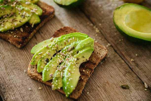 Avocado Toast Avocado Toast On A Wooden Cutting Board toasted bread photos stock pictures, royalty-free photos & images