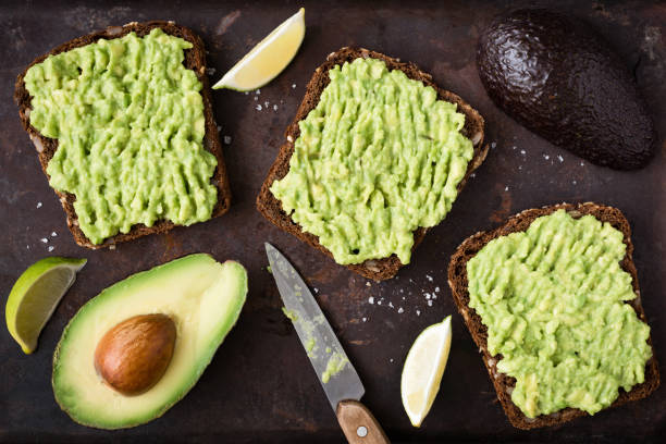 Avocado toast with whole grain rye bread. Top view Healthy avocado toast. Mashed avocado on whole grain rye bread on dark background. Top view vegan food crostini photos stock pictures, royalty-free photos & images