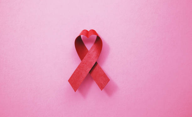 cinta de concienciación sobre el sida sobre fondo rosa - world aids day fotografías e imágenes de stock