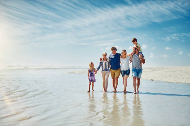 Away from the crowds with the people who truly matter Shot of a happy family going for a walk together at the beach multi generation family stock pictures, royalty-free photos & images