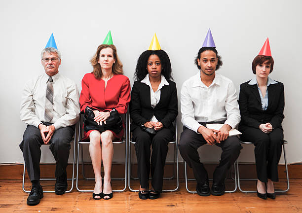 Awkward Office Party A group of business colleagues sitting awkwardly at an office party embarrassment photos stock pictures, royalty-free photos & images