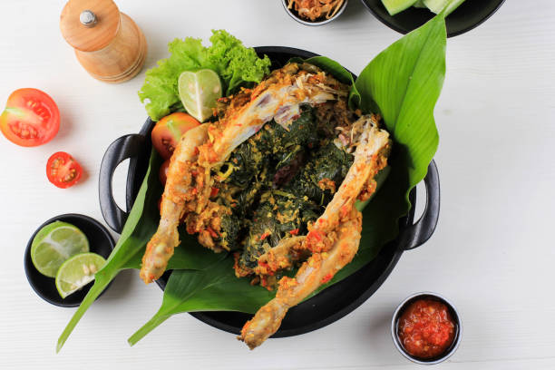 Ayam Betutu. Balinese Roast Chicken Stuffed with Cassava Leaves. stock photo