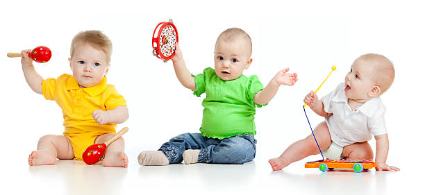 Babies playing with musical toys stock photo
