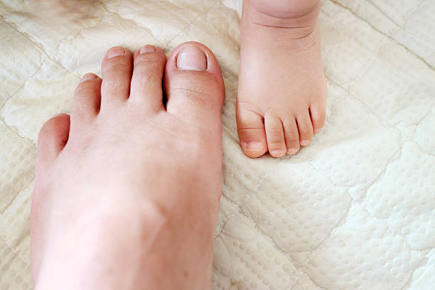 Baby and father feet on floor