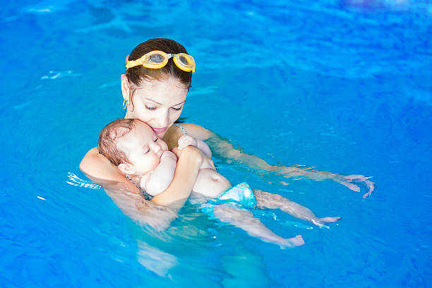baby and moher at  lesson - swimming baby stockfoto's en -beelden