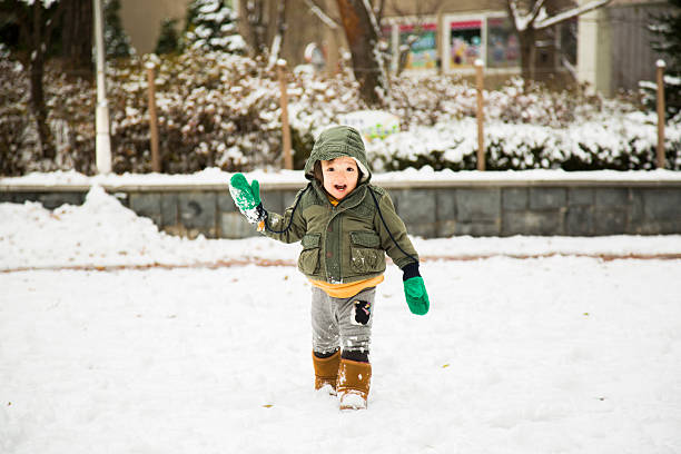 Baby At Playground In The Snow 7) Shot of a korean toddler in the snow. child korea little girls korean ethnicity stock pictures, royalty-free photos & images