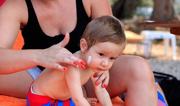 Baby back is applied with sunscreen stock photo