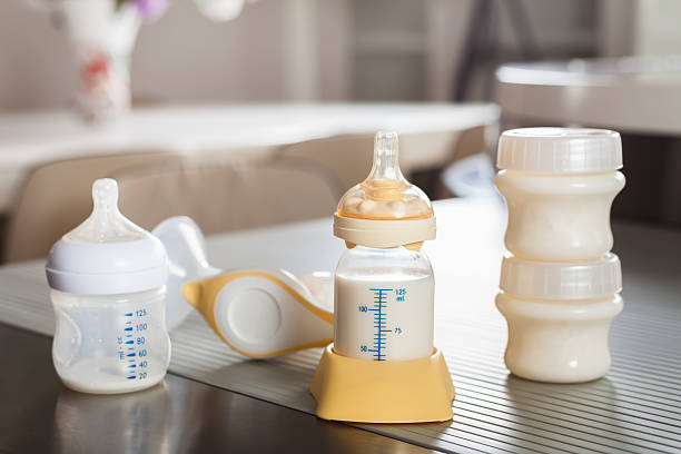 Baby bottle with milk and manual breast pump stock photo