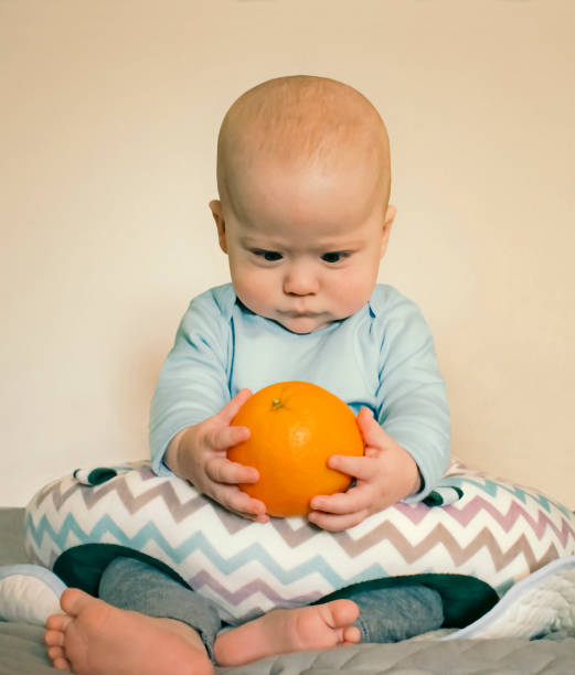 Baby Boy Baffled By an Orange stock photo