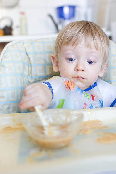 Baby boy having lunch stock photo