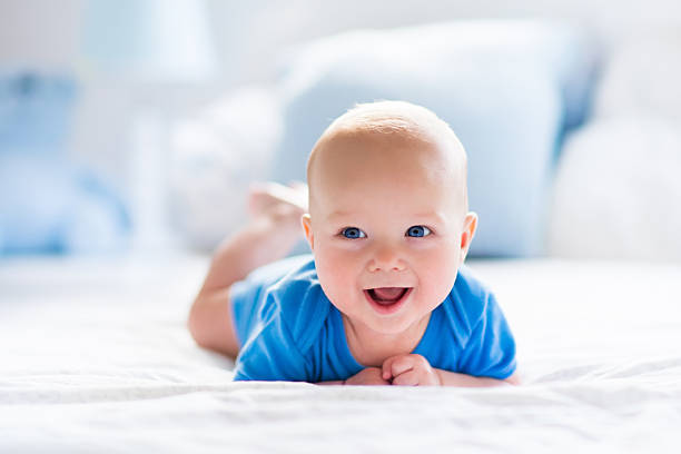 baby boy in weiß sonnigen schlafzimmer - lachen fotos stock-fotos und bilder