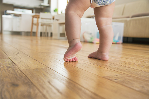 Baby Boy walking on wooden floor.