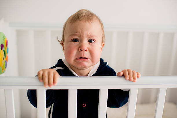 baby crying in the crib stock photo