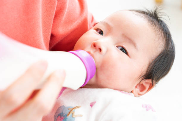 赤ちゃんからミルクを飲むのボトル - 乳育児 ストックフォトと画像