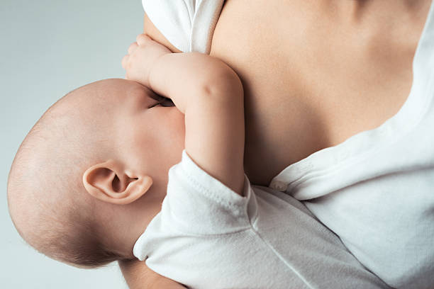 Baby feeds on MOM's breasts stock photo