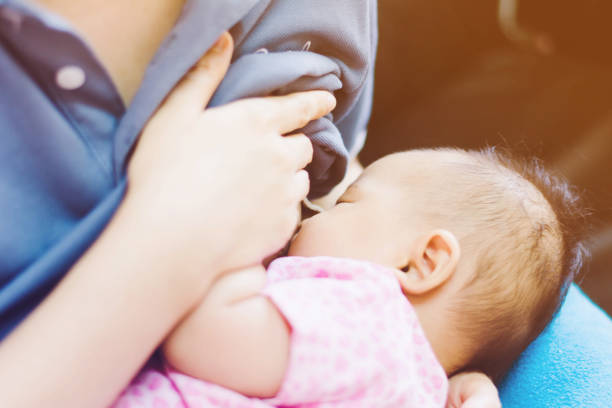 Baby feeds on  mother's breasts milk stock photo