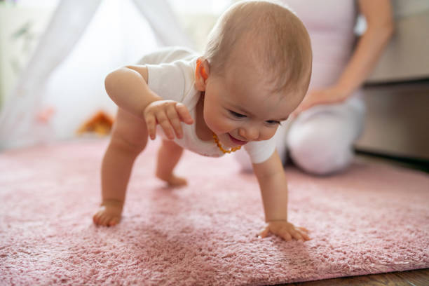 Baby girl crawling on the floor at home stock photo