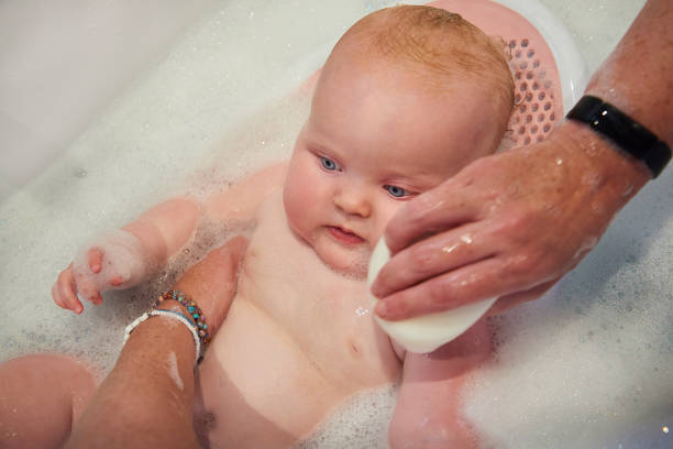 Baby girl in bath stock photo