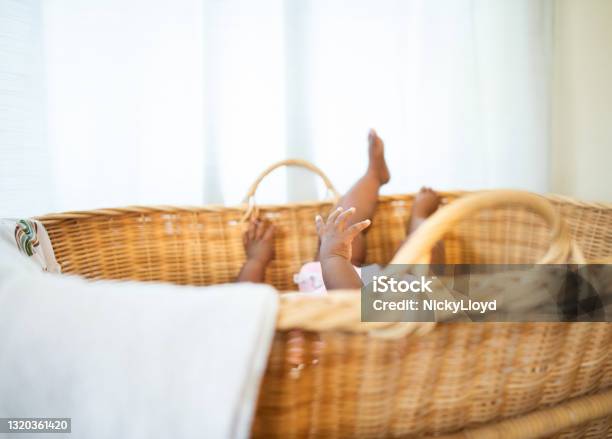 Baby girl lying in a wicker crib at home