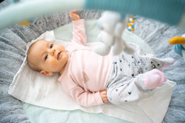 Baby girl on play mat stock photo