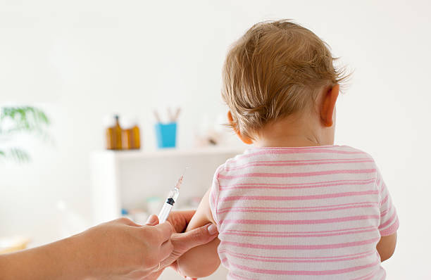 Baby Girl Patient Receiving Vaccine at doctor's office stock photo