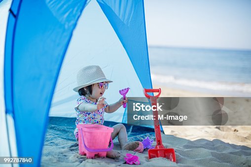 istock baby girl playing at summer beach 992787840